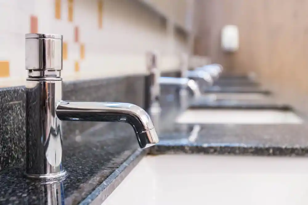 Close-up of touchless commercial sink faucets installed by Romano Plumbing for a modern restroom in Riverton, Utah — showcasing reliable plumbing solutions for offices, schools, and retail facilities.